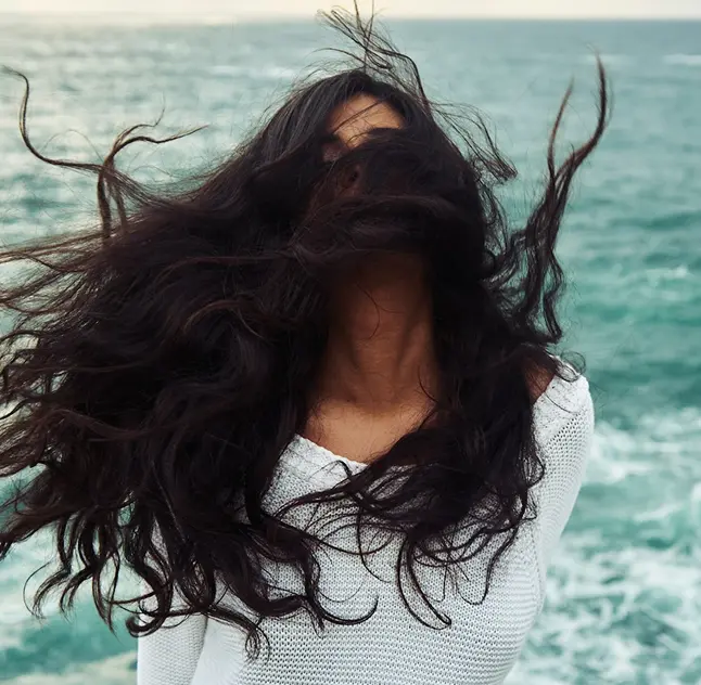 Ragazza con capelli lunghi al mare